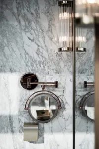 Modern lighting fixtures in a marble bathroom setting