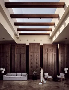 A modern living room with a grey sofa, armchairs, wooden panel walls, and a skylight ceiling.