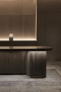 Modern office desk made of wood with curved legs and a sleek design in a minimalist office space.