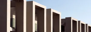 A modern residential exterior with concrete pillars and balconies.