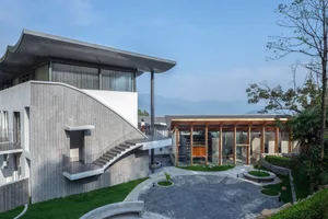 A modern, residential exterior featuring concrete, glass, and aluminium materials.