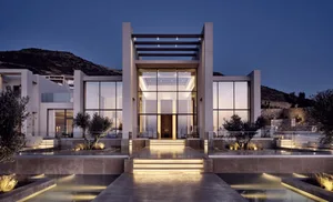 A modern residential exterior featuring large glass windows and doors.