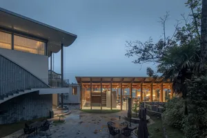 Modern residential exterior during winter with wooden framing and stone accents.