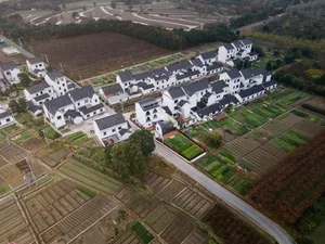 Aerial view of modern rural homes with concrete exteriors surrounded by farmland.