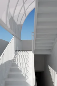 A white staircase with a metallic handrail in a minimalist architectural setting.