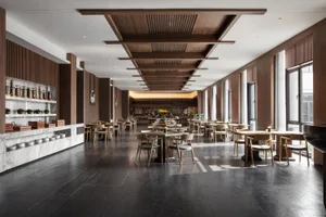 Industrial-style restaurant interior with marble countertops, wooden tables, and metallic bar.