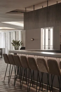 Modern bar interior with concrete countertop and glass partitions.
