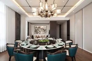 Modern dining room with round table, chairs, and chandelier.