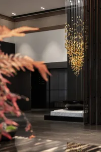 A modern hotel lobby interior featuring a metallic pendant lighting fixture.