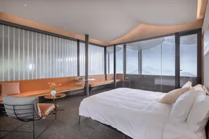Modern minimalist bedroom featuring a white bed on a textured flooring