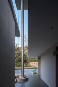 Modern residential corridor featuring concrete and stone materials with an exterior view.
