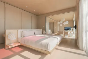 Modern minimalist bedroom featuring a low-profile bed, square windows, and light wood finishes.