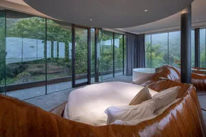 Modern bedroom interior with glass walls and a round bed.