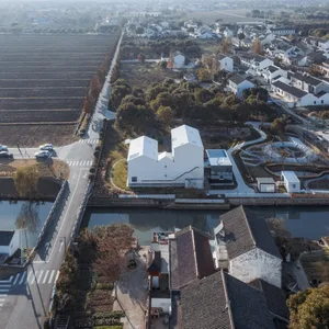 Aerial view of a modern residential neighborhood with white buildings and greenery.