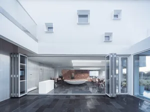 Modern conference center featuring a glass reception area, concrete furniture, and white finish walls.