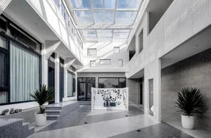 A minimalist modern residential interior with white ceramic tiles, granite walls, and large glass windows.