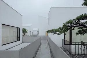 A serene, minimalist residential exterior composed of concrete materials with a quiet, natural atmosphere.
