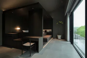A modern minimalist living space featuring wooden furnishings and a large window with a view of greenery.