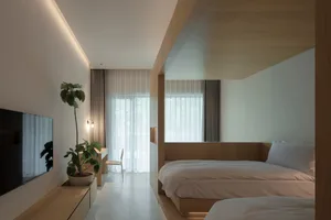 Modern bedroom featuring minimalist design with wooden furniture and white bedding.