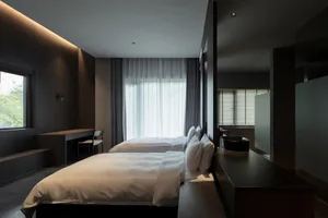A minimalist white bedroom with two beds, white fabric, and a minimalist design.