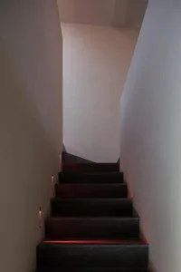 Modern concrete staircase with red lighting in a minimalist architectural setting