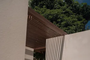 Detailed architectural exterior featuring a wooden lattice design with surrounding greenery.