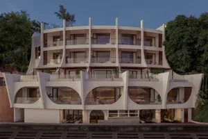 An image showcasing a modern residential building with concrete exterior and curved balconies.