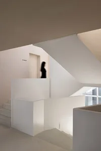 極簡室內空間，混凝土牆面搭配白色樓梯。