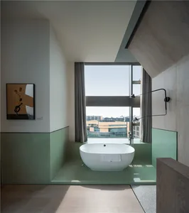 A modern bathroom featuring a glass-enclosed bathtub with a view of the city.