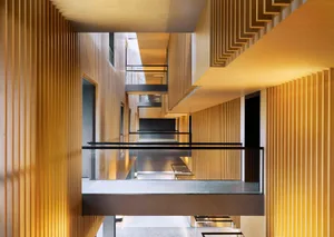 A modern interior corridor featuring wooden walls and lighting.