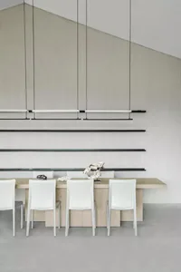 Modern dining room with white chairs and a wooden table.