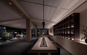 A modern hotel lobby featuring concrete flooring, wooden seating, and light metal accents.