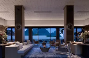 Modern lounge area with glass walls, comfortable seating, and a cozy atmosphere.