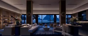 A modern living room with minimalist furniture, large windows, and a central coffee table.