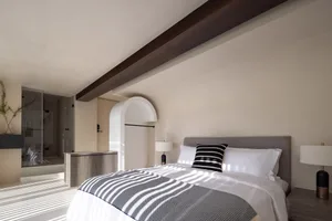 Modern minimalist bedroom featuring concrete and wooden materials.