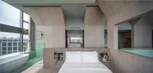 Modern minimalist bedroom featuring white bedding, a large bed, and a minimalist design with wood accents.