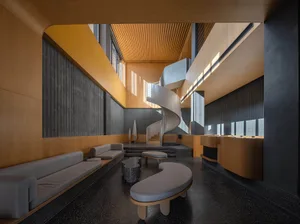 A modern office space featuring black and white color scheme, with wooden accents and a spiral staircase.