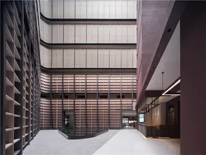 A modern office space with light-colored brick walls and glass panels, featuring a reception area and open-plan workspaces.