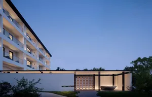 Modern residential building with concrete, glass, and metal elements.