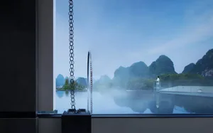 A modern resort features a glass swimming pool with a scenic view of mountains and mist.