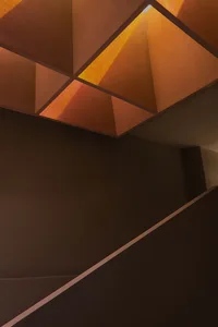 Modern concrete staircase with geometric design and orange lighting
