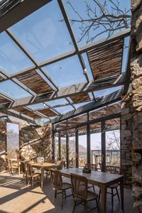 A cozy coffee shop with a glass rooftop and stone walls