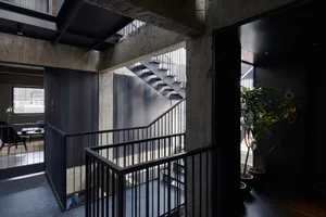 A minimalist interior with a modern metal railing and black elements.