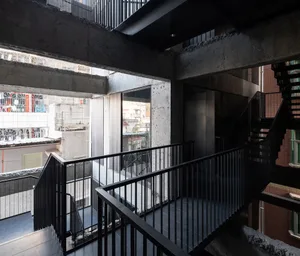 Modern industrial office space with concrete elements and a spiral staircase.