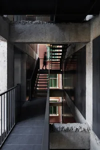 Concrete staircase with steel railings and a person walking up it.