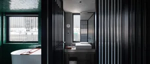 Modern industrial bathroom featuring metal, glass, and concrete elements.
