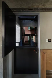 Modern interior with a black metal door and concrete walls.