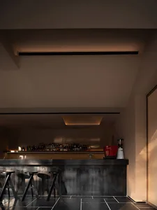 Modern industrial bar with black metal bar stools and a long bar top.