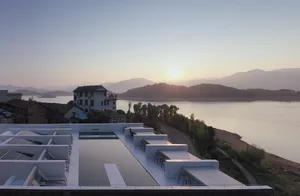 A minimalist rooftop pool with concrete features against a serene lake backdrop.