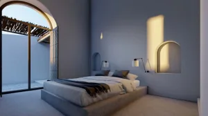 Modern bedroom with concrete floor and walls, featuring a double bed with white bedding and a window with an arched opening.